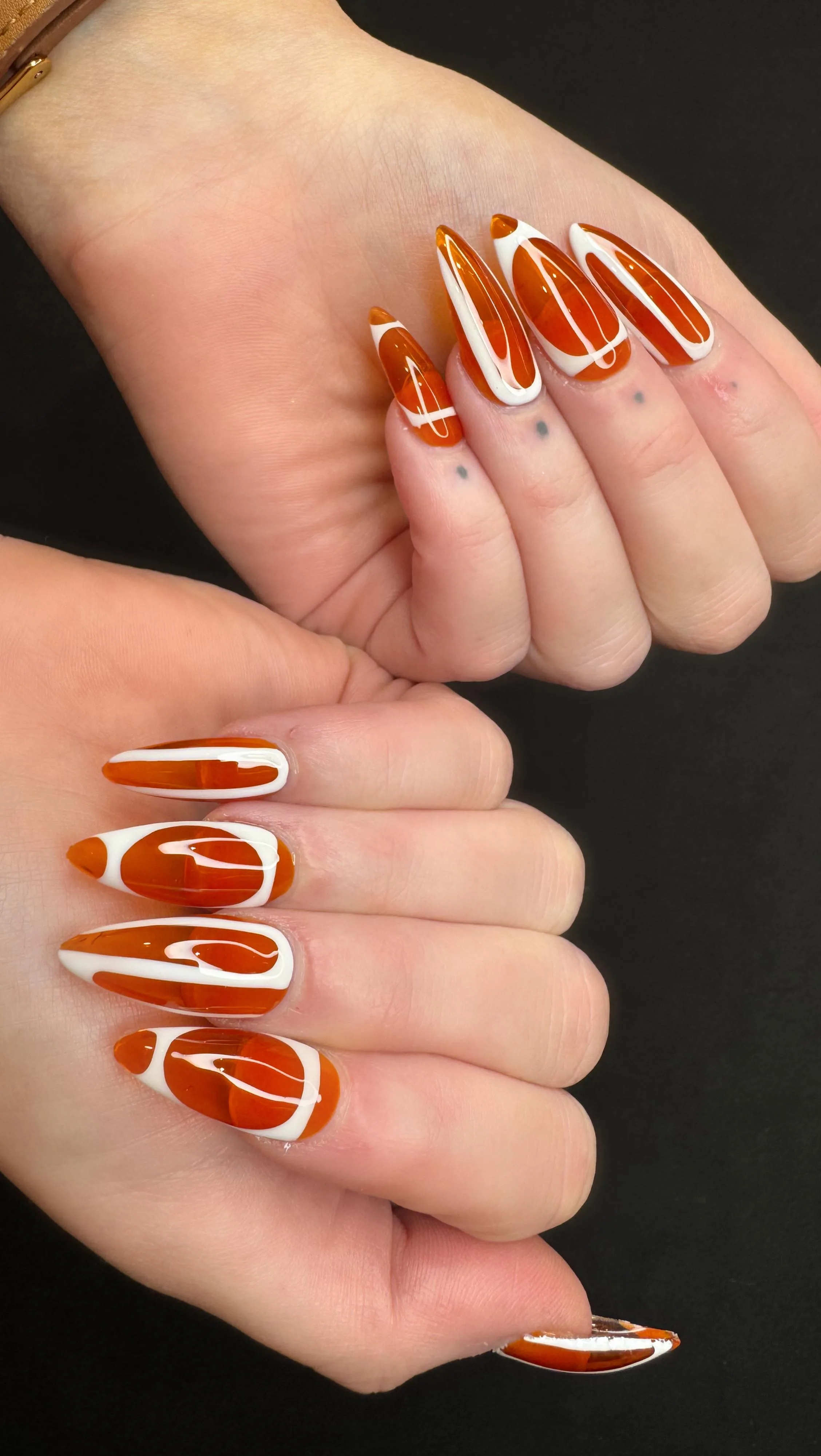 Burnt-orange and white swirl almond nails, high-gloss finish